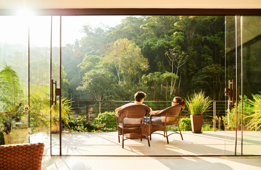 Wide shot of a couple sitting outside, enjoying the coziness of their outdoor space.